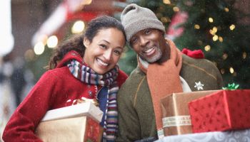 Couple with Christmas presents on street, portrait
