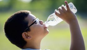 Nine year old boy drinking water from a bottle