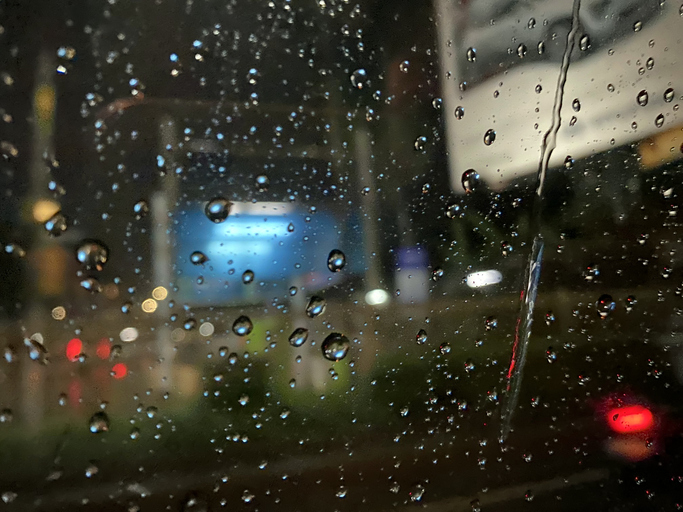 Raindrops on the car window with a nighttime atmosphere.