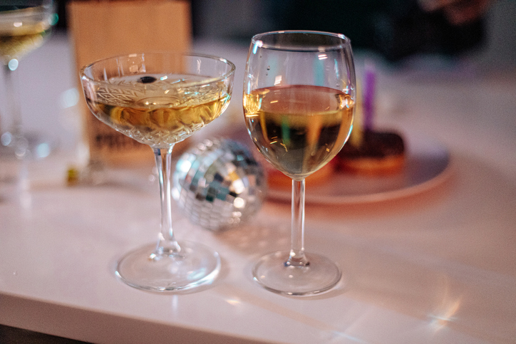 Two glasses of champagne and a disco ball on a table, ready for celebration