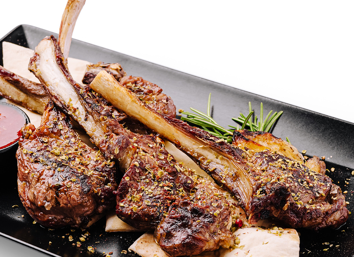 Delicious grilled lamb chops served with herbs and sauce