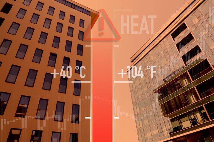 Graphic of a thermometer with high temperature reading against a blurred city building during a summer heatwave